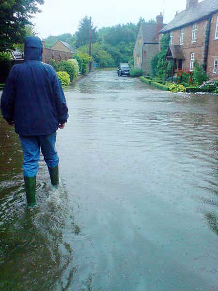 Aldington (1 of 3). Aldington Village Street was taken on Friday evening. Here the flooding is due to the quantity of rain water not getting down the drains quickly enough. The water got into at least two of the adjacent houses. Photo: Louise & John Sparrow.