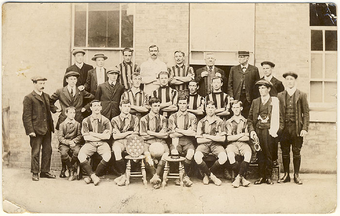 Badsey United team photo with two trophies - a shield and a cup. The man with the straw hat is Julius Sladden. Other names unknown.