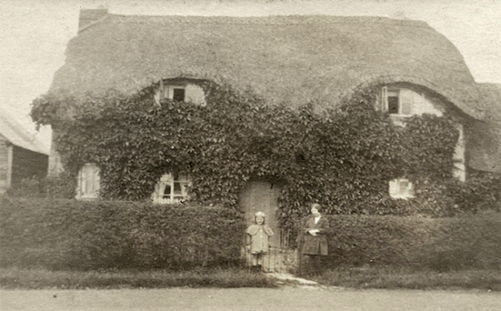 The thatched vicarage in about 1900.  The people outside have not been identified.
