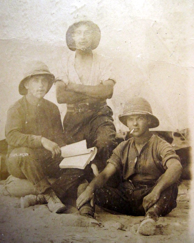 George Mason holding a book with two of his fellow soldiers in the desert at Alexandria. 