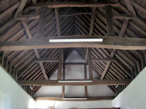 49. The queen-strut roof of the nave. The paired vertical timbers are placed symmetrically on the horizontal tie beam to  support the side purlins. 