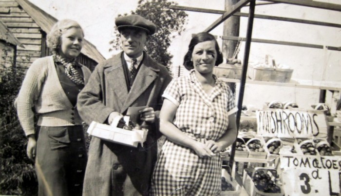Billy and Eva Dolphin with their daughter, Barabara (b.1918). The range of crops for sale includes tomatoes and mushrooms.