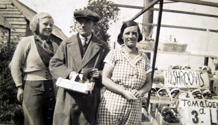 Billy and Eva Dolphin with their daughter, Barabara (b.1918).   The range of crops for sale includes tomatoes and mushrooms.