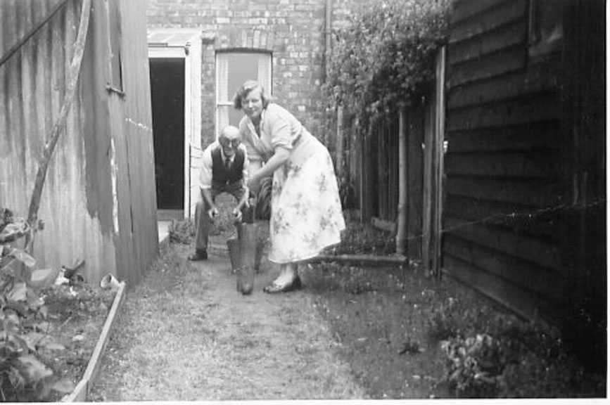 The photograph shows Emma Collet playing cricket, with Percy Butler as the wicket keeper, in the back of number 36 Willersey Road on the twenty eighth of June 1958, some three & a half months before Percy Butler died