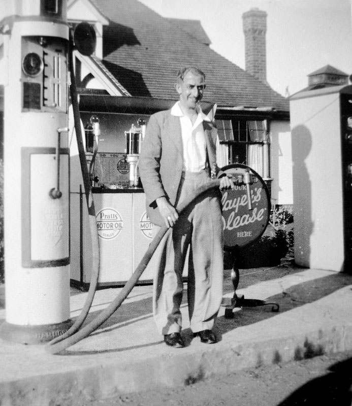 This shows an attendant operating one of the pumps and the display for Pratts Motor Oil behind.