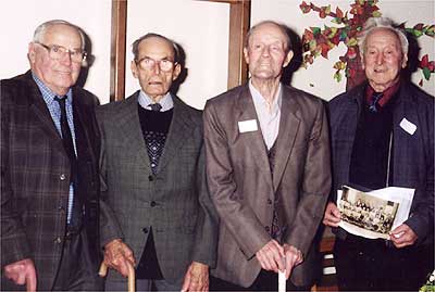 Fred Roberts, Fred Mason, Jim Brailsford and Deric Anderson, the most senior former pupils present. Deric is holding a class photo showing himself as a young child at the school in 1920. 