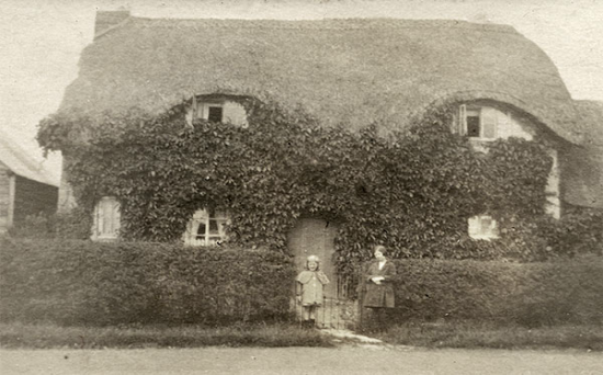 The thatched vicarage in about 1900. The people outside have not been identified.